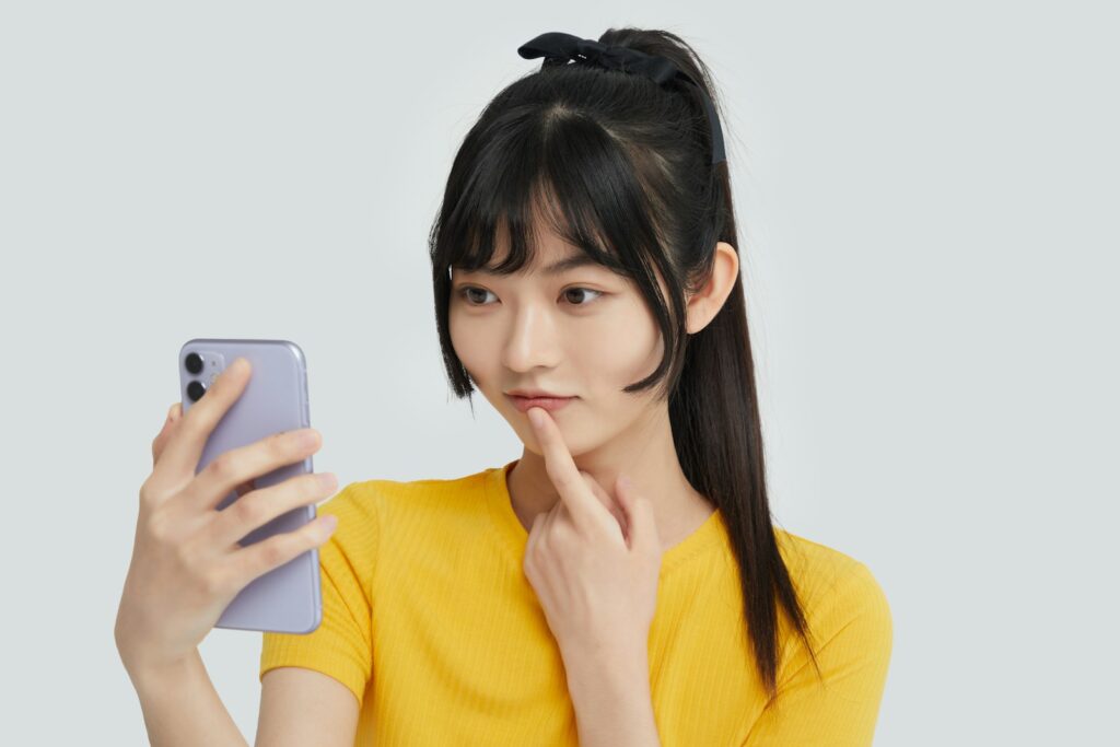 a woman in a yellow shirt holding a cell phone